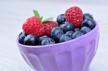 Raspberry with blueberry in a bowl on table