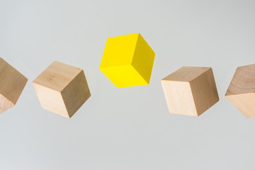 Business concept - Abstract geometric real floating wooden cube on grey background and it's not 3D render. the symbol of leadership, teamwork and growth.