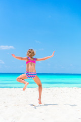 Sporty little girl having a lot of fun on the white sandy beach