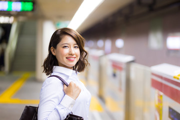 young woman waiting the subway on platform.