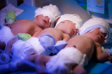 Noworodki trojaczki są w szpitalu położniczym pod urządzeniem z promieniowaniem ultrafioletowym - 154858819