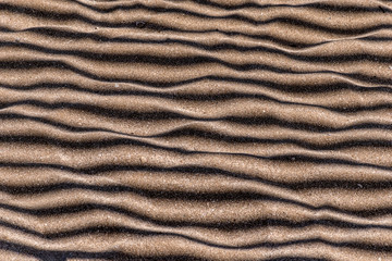 Sand with parallel stripes of shadows
