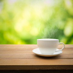 Cup of coffee on table with garden in morning