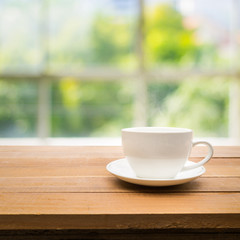 Cup of coffee on table with garden in morning