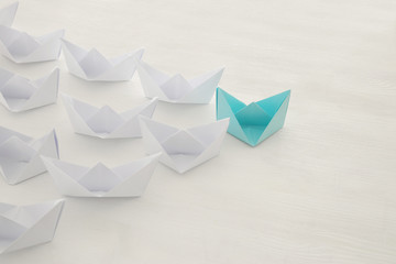 leadership concept, blue paper boat leading followers