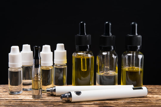 Electronic cigarette on a background of six bubbles with fluids of different flavors