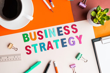 Business strategy word on desk office background with supplies.Colorful of business working table.marketing concept