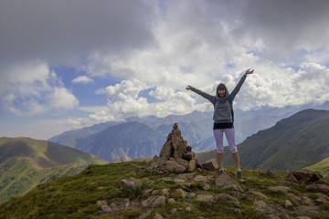 Young woman are standing on top of a mountain and enjoying. Almaty, peak named Furmanov