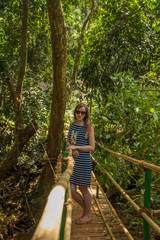 Young woman in the jungle on the bridge in tropical spice plantation, Goa, India