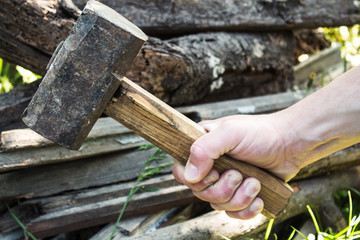 The hand of a man with a large hammer