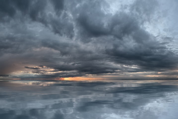 Fototapeta premium Sunset by the sea, with a gloomy sky