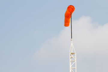 Windsock against blue sky and clouds
