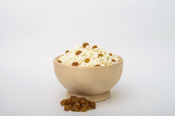 Cottage cheese with raisins in wooden bowl