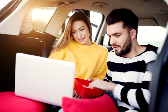 Teenage Friends Watching Movie In A Car. Eating Popcorn.