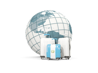 Luggage with flag of guatemala. Three bags in front of globe