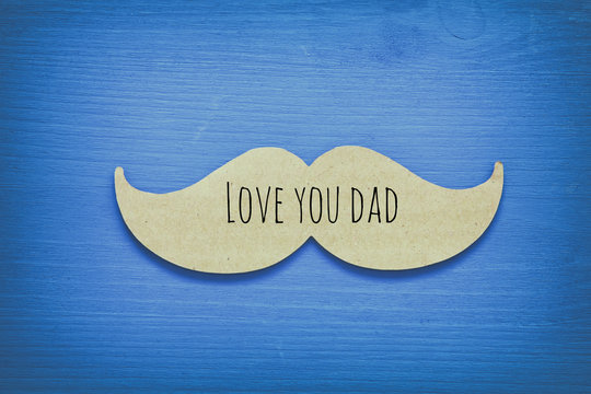 Blue wooden background and paper mustache. fathers day concept