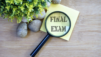 Ornamental trees, stones Small, magnifying glass, sticky note with text final exam