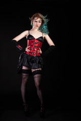 Woman in fetish red leather corset on black background in studio photo. BDSM and dominatrix