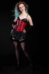 Sexy sensual woman in fetish leather corset on black background in studio photo. BDSM and dominatrix