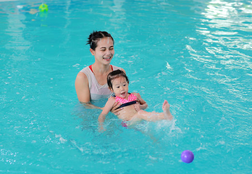 Mother with baby in swimming pool training.