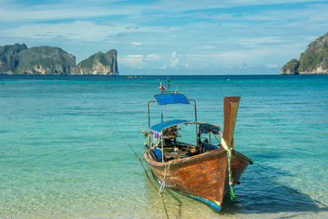 Naklejka na ściany i meble Taxi long-tail boat docked on the tropic beach