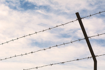 Barbed wire against blue sky.
