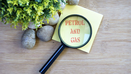 Ornamental trees, stones Small, magnifying glass, sticky note with text petrol and gas