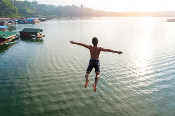 Man jumping into lake retro on Longest wooden bridge in sangkhlaburi Thailand