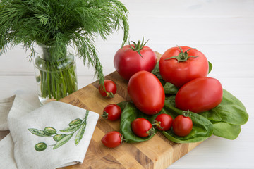 Olive oil, parsley, spinach and branch of tomatoes on a white background