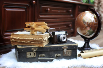 composition on a wooden floor vintage globe with old leather suitcase