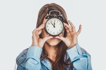 Morning woman in big shirt holding clock.