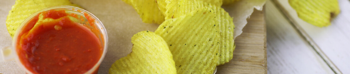 Horizontal bakground of potato chips on a table