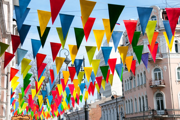 Decorative multi colored triangle flags against the background of city