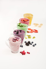 Close-up view of fresh fruit smoothies in glass cups isolated on white