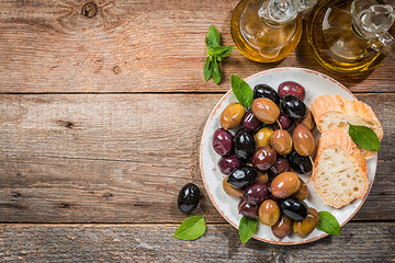 Olive oil, different olive fruites and fresh bread.