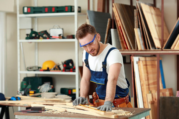 Handsome young carpenter in workshop