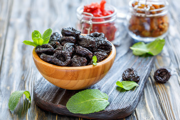 Wooden bowl with dried prunes.