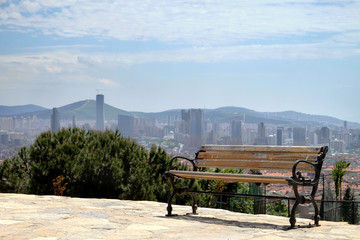 Public bench on the top of the hill with the city background