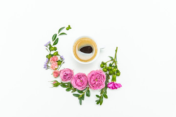 Top view of beautiful pink roses with green leaves and cup of coffee isolated on white