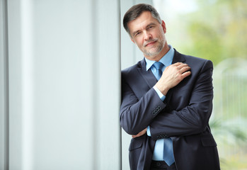 cheerful businessman with arms folded looking at the camera.