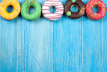 glazed donuts on a blue wooden background with copy space for your text. Top view