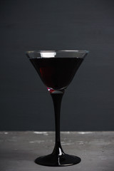 Black martini cocktail on the rustic background. Shallow depth of field.