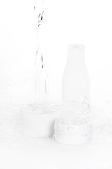 water drops falling on bottle and boxes isolated on white