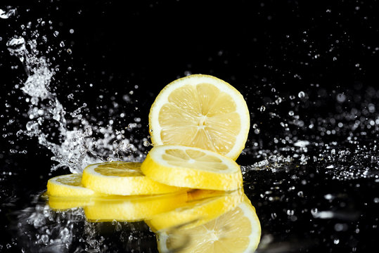 Close-up View Of Fresh Sliced Lemon With Water Drops Isolated On Black