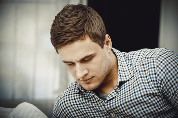 Handsome young adult man in bedroom.