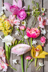 Top view of beautiful various blooming flowers on wooden table