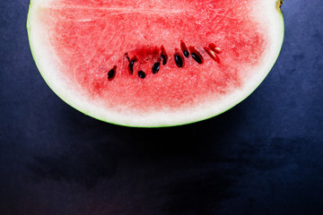half of ripe watermelon on a black background