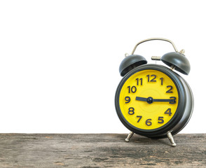 Closeup black and yellow alarm clock for decorate show a quarter past nine o'clock or 9:15 a.m. on old brown wood desk isolated on white background with copy space