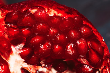red sliced pomegranate on a blue abstraction background close up