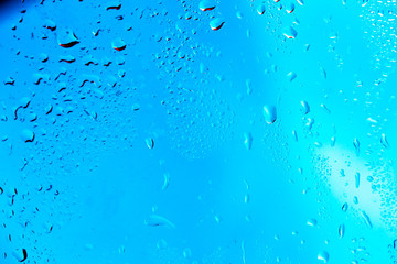 Drops on the glass rain blue background